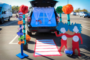 A car is decorated for a trunk or treat event. The decorations include characters from Dr. Seuss. 