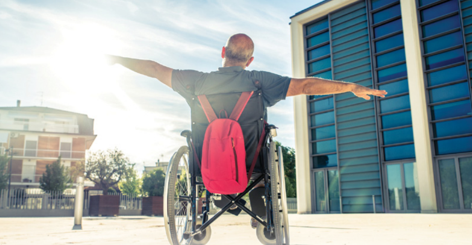 Man in wheelchair stretching his arms out