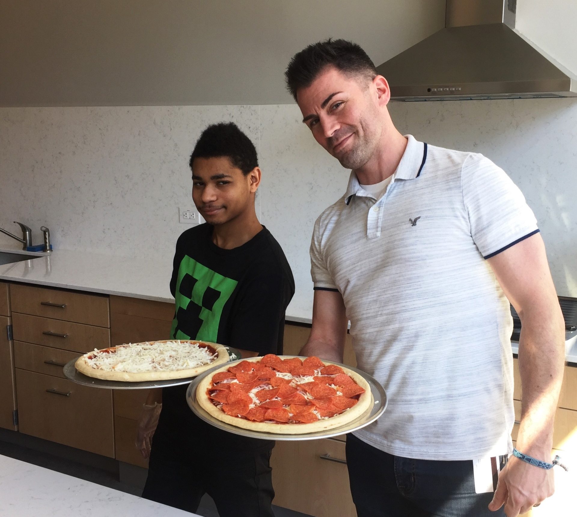 Jaysen H. Clough-Medora helps a student make his own pizza at The Bancroft School.