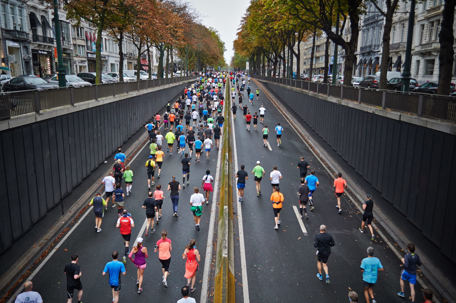 dozens of people run down a street