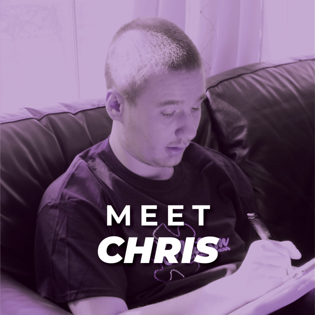Chris; a man with short hair sitting on a couch and writing with a pen