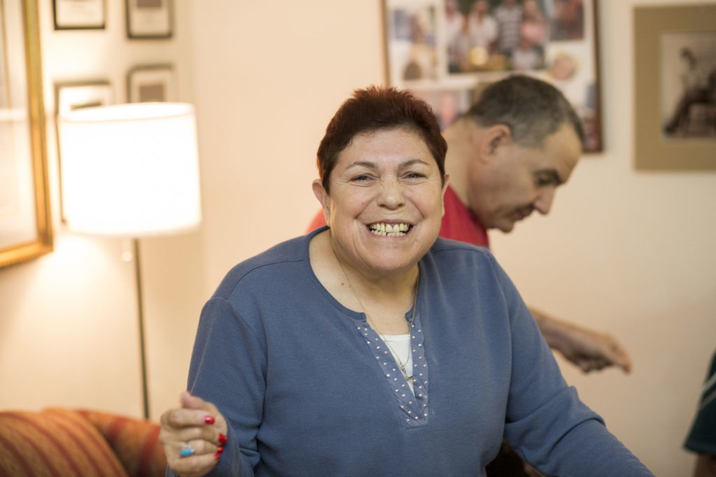 Female resident with light skin and short brown hair in a blue sweater smiling