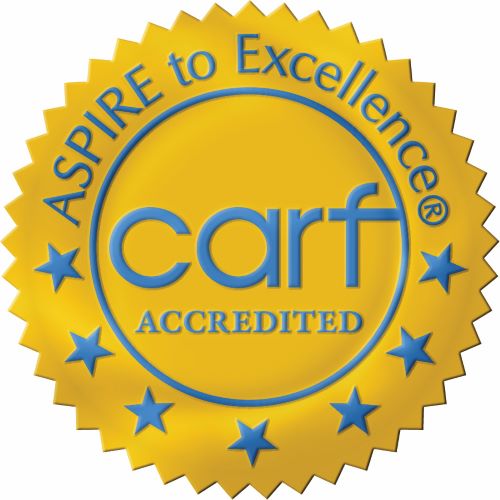 The CARF accreditation goal seal, with blue letters