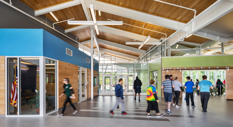 several people walk in the lobby of a Welsh Campus building