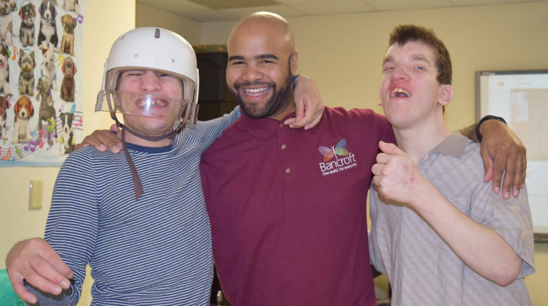 Paraprofessional smiling and posing for the camera with two male individuals served