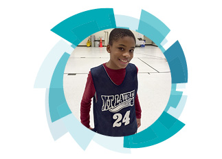 A young boy wearing a basketball jersey and smiling at the camera
