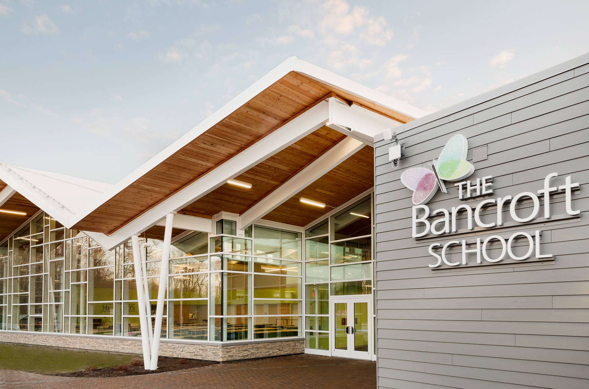 the Bancroft School building, a grey building with white trimmed window panes and a wood finish with the words "The Bancroft School" printed on it
