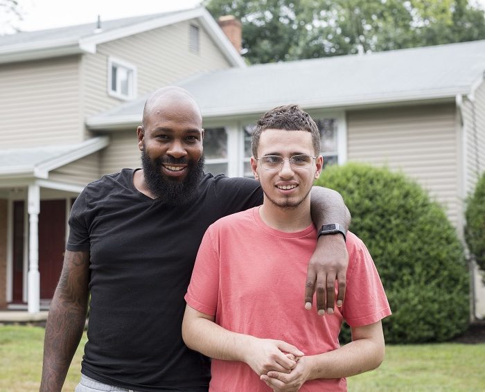 Direct Support Professional and Student smiling in front of their community group home for children