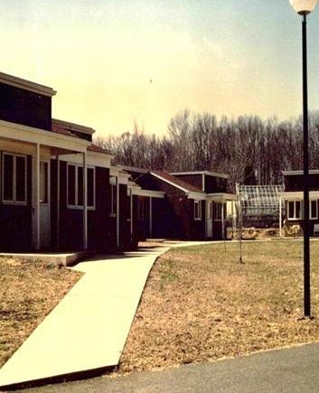 Original Mullica Hill Campus with five dark red buildings with white details connected by a sidewalk