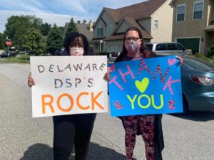 Two adult women standing and holding signs. One sign says "Thank you DSP" and the other sign says "DSPs Rock!"