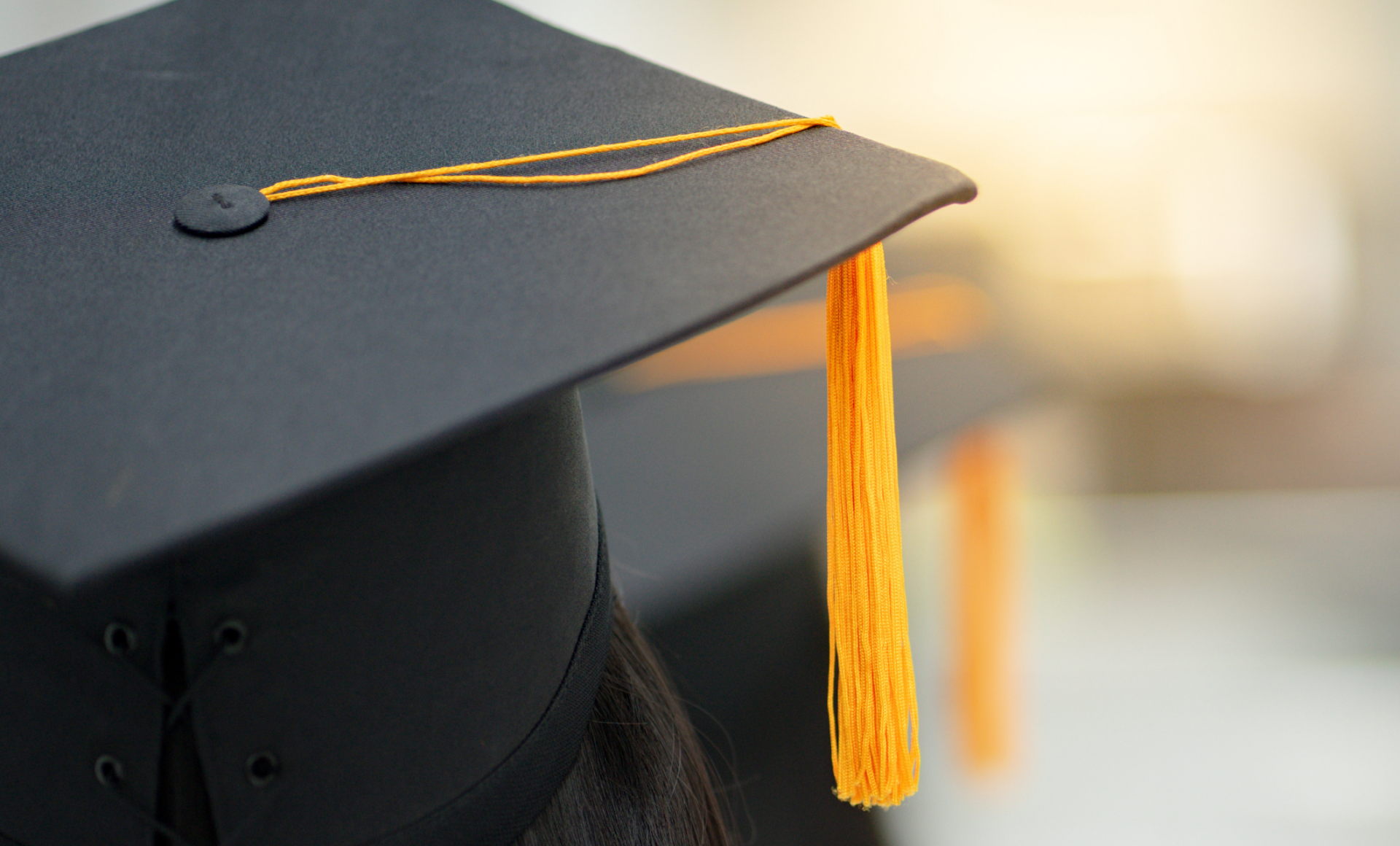 close-up of individual wearing graduation cap, viewpoint is behind the person