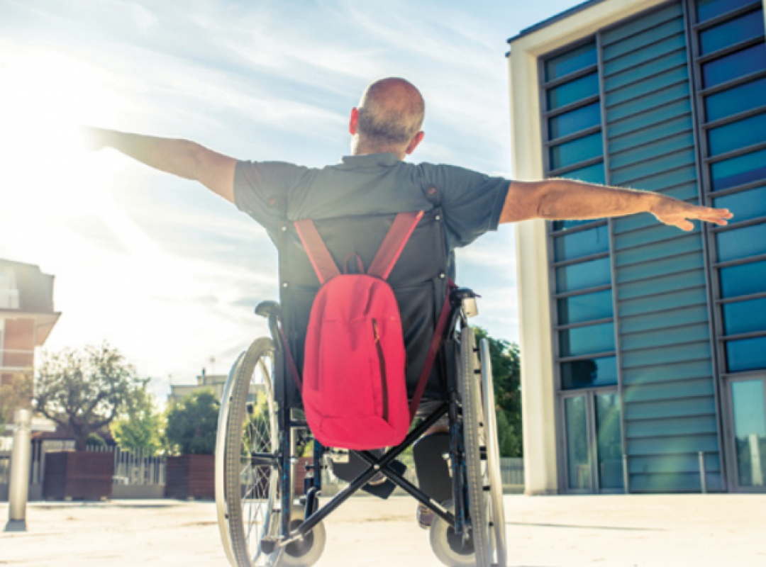 Man in wheelchair stretching his arms out