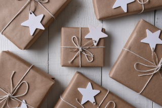 packages wrapped in brown paper with white rope tying it together and a white star tied to the string