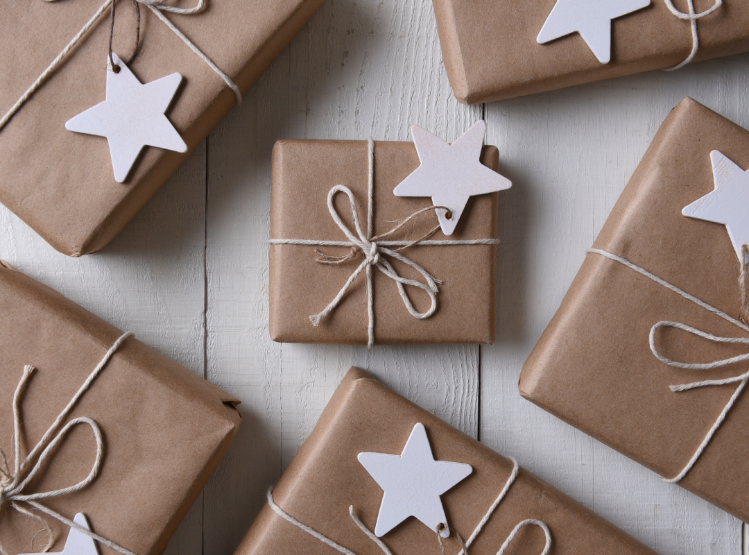 packages wrapped in brown paper with white rope tying it together and a white star tied to the string