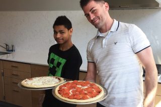 Jaysen H. Clough-Medora helps a student make his own pizza at The Bancroft School.