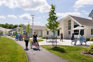 in the Welsh Campus, multiple people walk and ride on a side walk