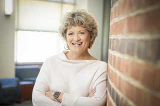 Toni Pergolin, CEO of Bancroft, leans against a brick wall