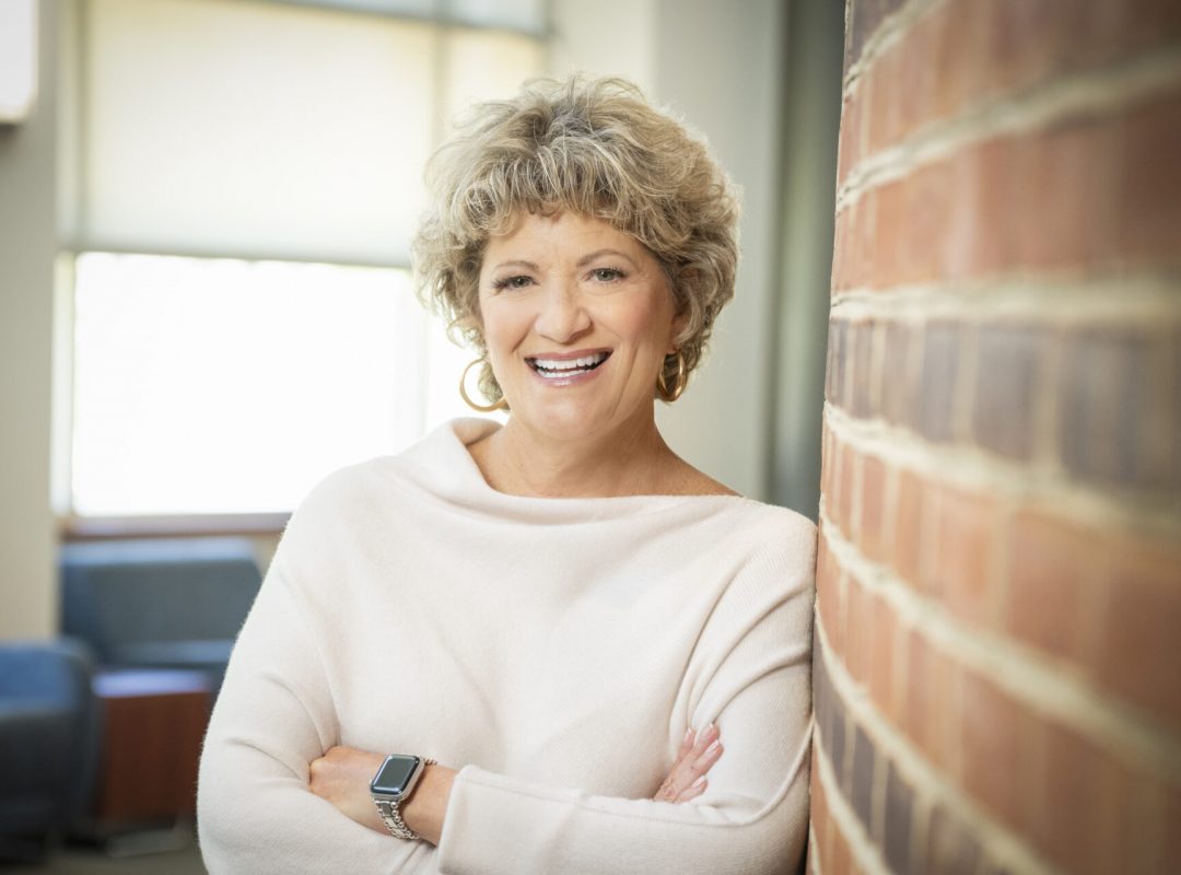 Toni Pergolin, CEO of Bancroft, leans against a brick wall