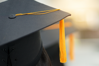 close-up of individual wearing graduation cap, viewpoint is behind the person