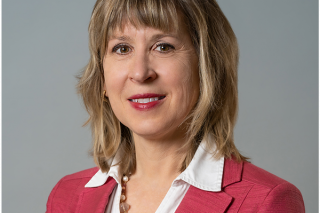 Bancroft's Chief Clinical Officer Karen Lindgren's headshot while smiling in a pink blazer