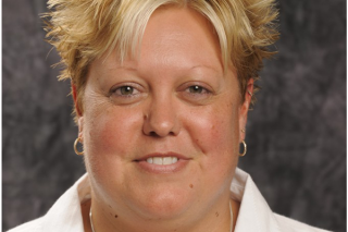 Michelle Habingreither, a light-skinned woman with blonde hair wearing a white button up shirt, smiling