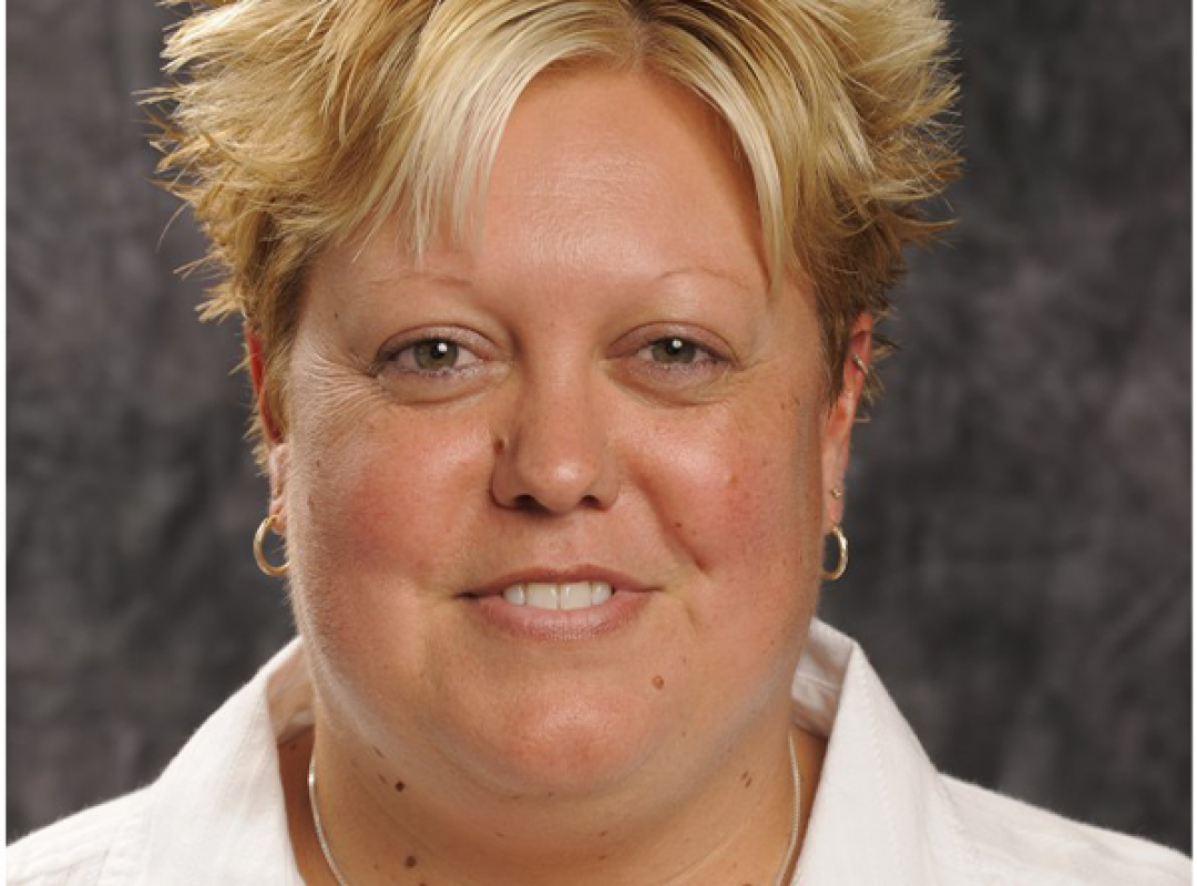 Michelle Habingreither, a light-skinned woman with blonde hair wearing a white button up shirt, smiling