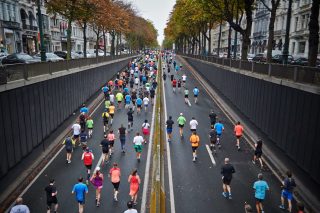dozens of people run down a street