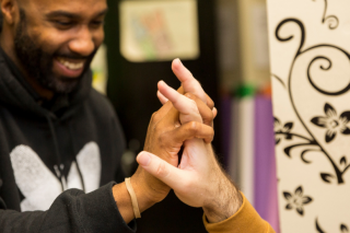 Male paraprofessional in Bancroft sweatshirt giving a high five to another male.