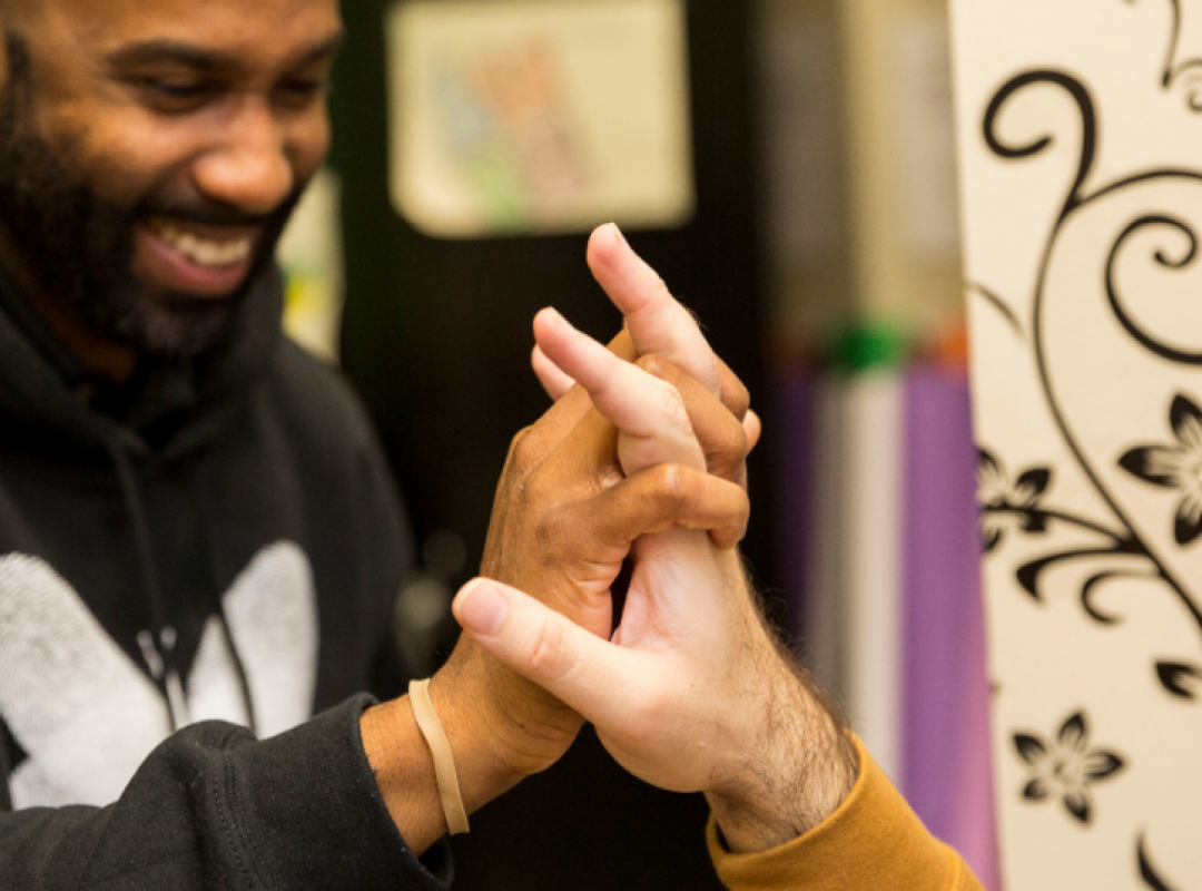 Male paraprofessional in Bancroft sweatshirt giving a high five to another male.